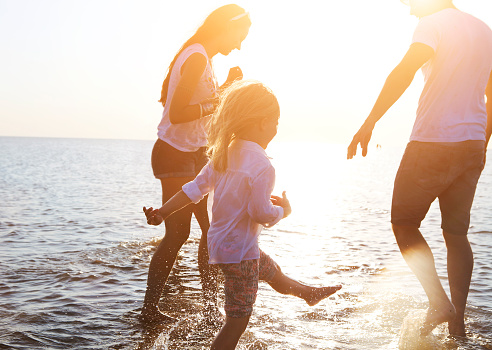 Family of three playing in ocean